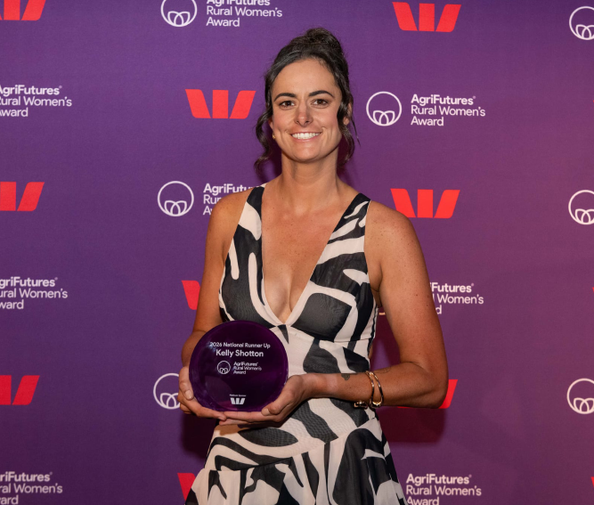 Kelly Shotton holding Rural Women’s Award trophy while standing in front of a purple event backdrop featuring Rural Women’s Award and sponsor logos.